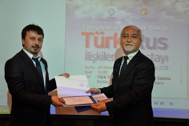 Türk-Rus İlişkileri III. Çalıştayı, Ankara 2011 (Kemaloğlu, dönemin Atatürk Araştırma Merkezi Başkanı Prof. Dr. Cezmi Eraslan'dan katılım belgesini alırken)